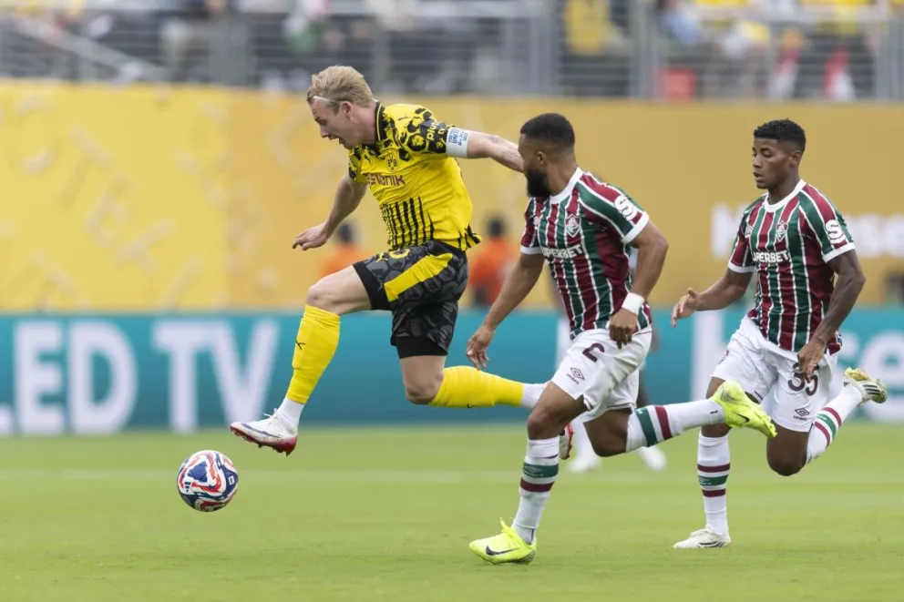 Julian Brandt (izq.), del Borussia Dortmund, trata de superar a dos rivales. Foto: EFE.