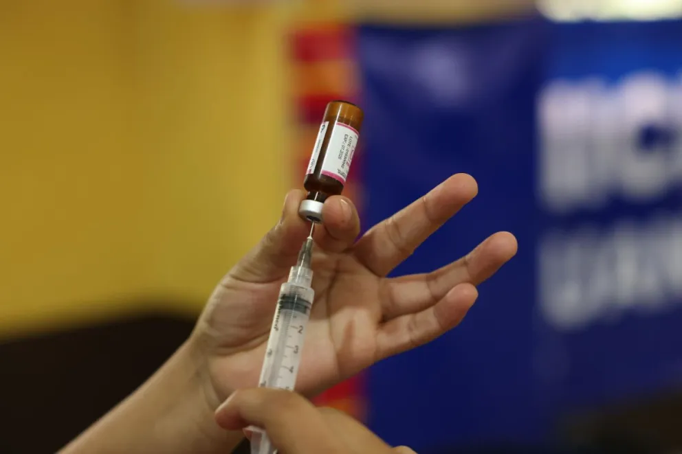 Fotografía de archivo del detalle de las manos de un trabajador sanitario al preparar una vacuna contra el sarampión. Foto: EFE