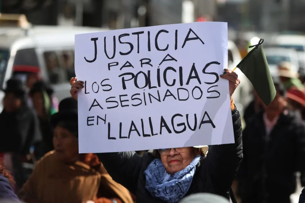 Personas participan durante una marcha pidiendo justicia por la muerte de policías durante enfrentamientos con seguidores del expresidente Evo Morales, este martes en La Paz. Foto: EFE