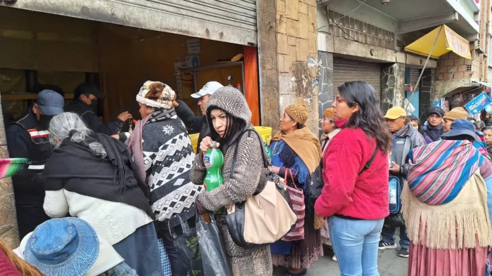 Luego de hacer fila por varias horas, personas compran aceite a granel en el sector de abarrotes de la calle Gallardo. Foto: Marco Belmonte