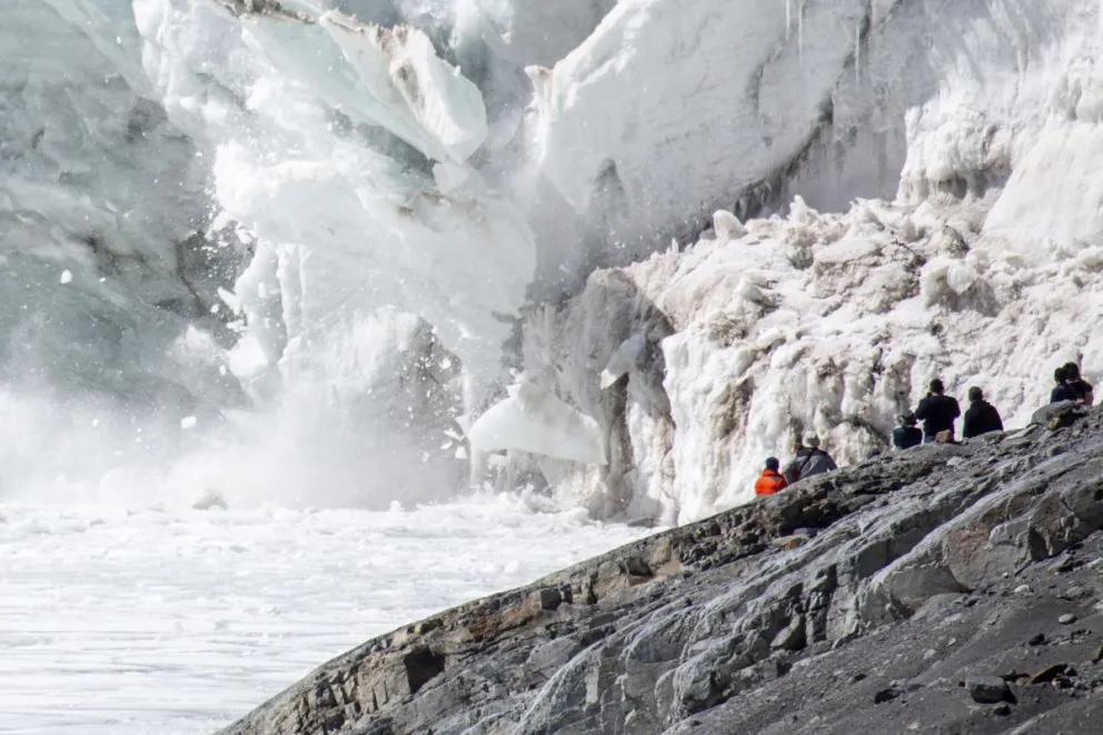 Personas observan el desprendimiento de un fragmento de glaciar en la laguna glacial Ventanani este sábado, en Pucarani (Bolivia). Foto: EFE