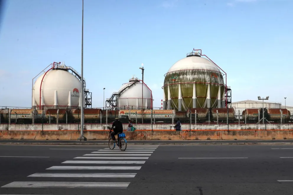 Un ciclista pasa por las instalaciones de la Sociedad Ivoriana de Refinado (SIR) en Abiyán, Costa de Marfil, 17 de junio de 2025. Foto: EFE