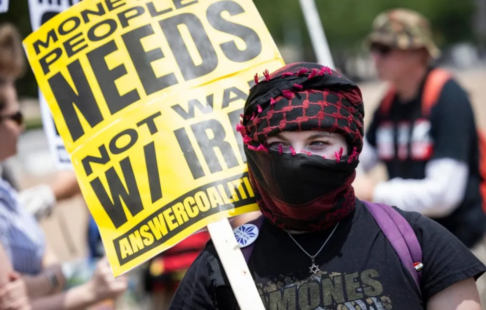 Una persona lleva una pancarta este domingo en Washington, en protesta al ataque de Estados Unidos a las bases nucleares de Irán. Foto: EFE