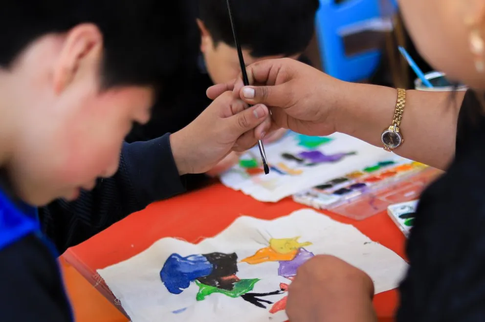Una maestra guía la mano de un niño durante un taller de pintura en el MNA. Fotos: EFE 