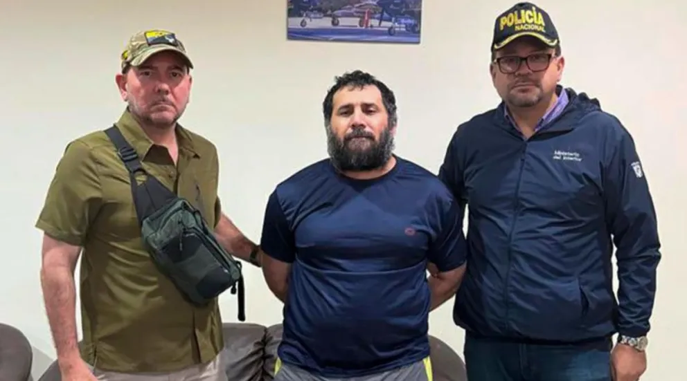 El narcotraficante José Adolfo Macías Villamar "Fito", con dos autoridades. Foto: EFE