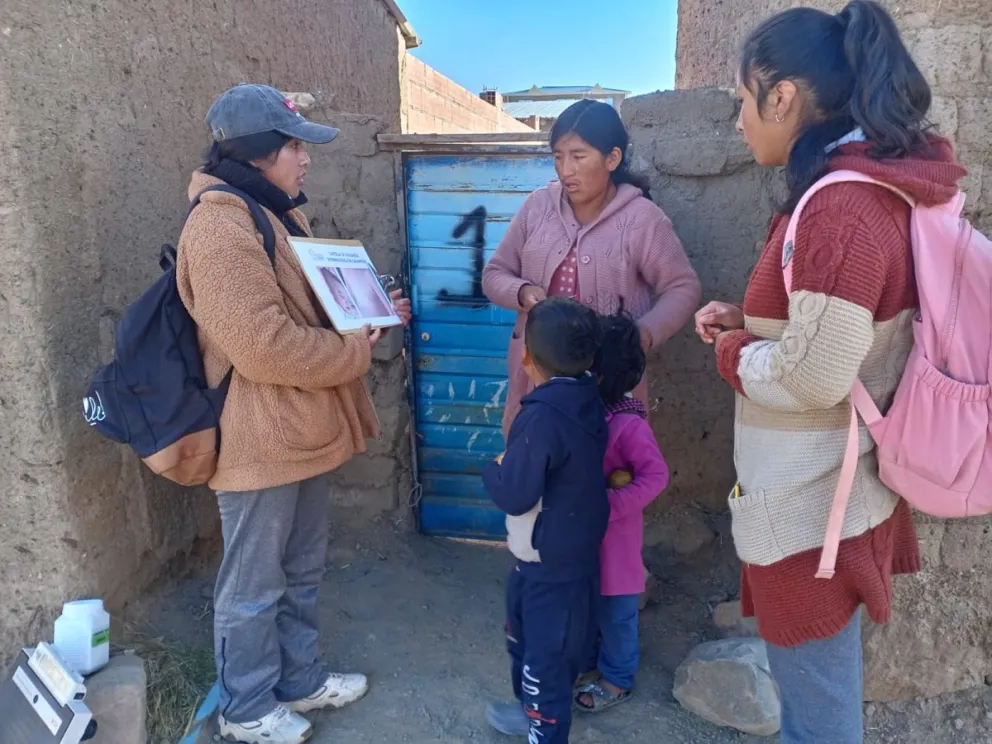Una funcionaria de salud explica la enfermedad a una familia en Potosí. Foto: Sedes Potosí