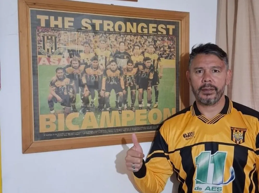 Rubén Gigena posa con una fotografía del equipo bicampeón de 2003 y la camiseta que usó el plantel en esa campaña. Foto: Rubén Gigena