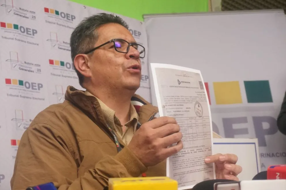 El secretario de Cámara del TSE, Fernando Arteaga, muestra la resolución emitida este miércoles. Foto: APG