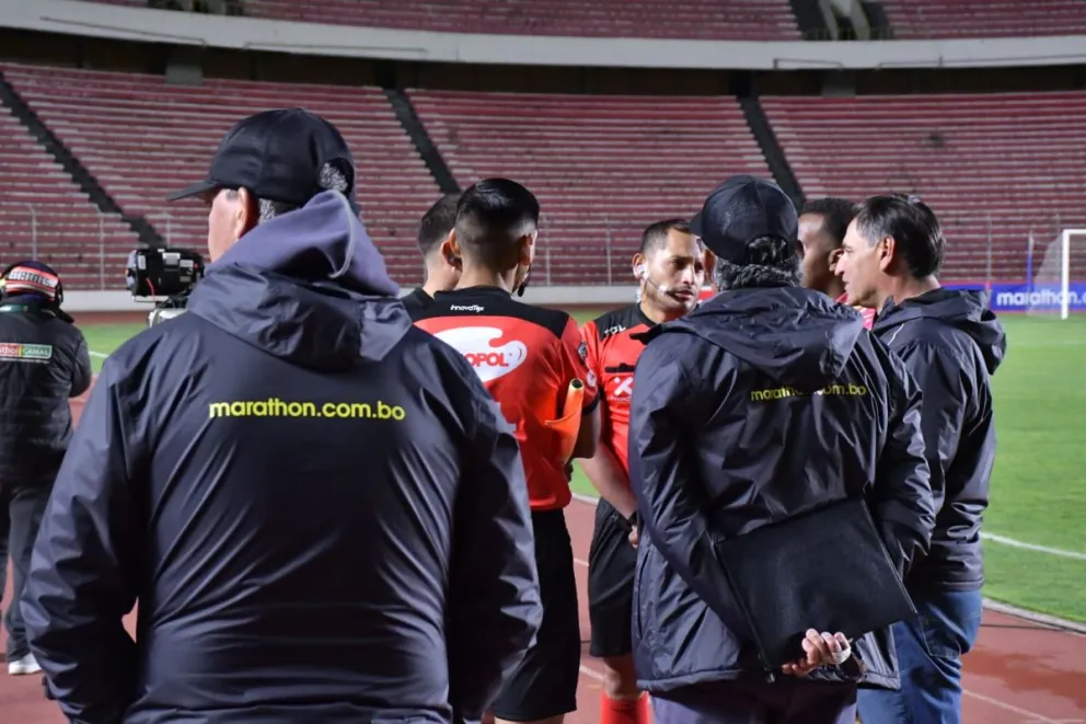 Los árbitros del partido conversan con miembros del cuerpo técnico de The Strongest. Foto: APG