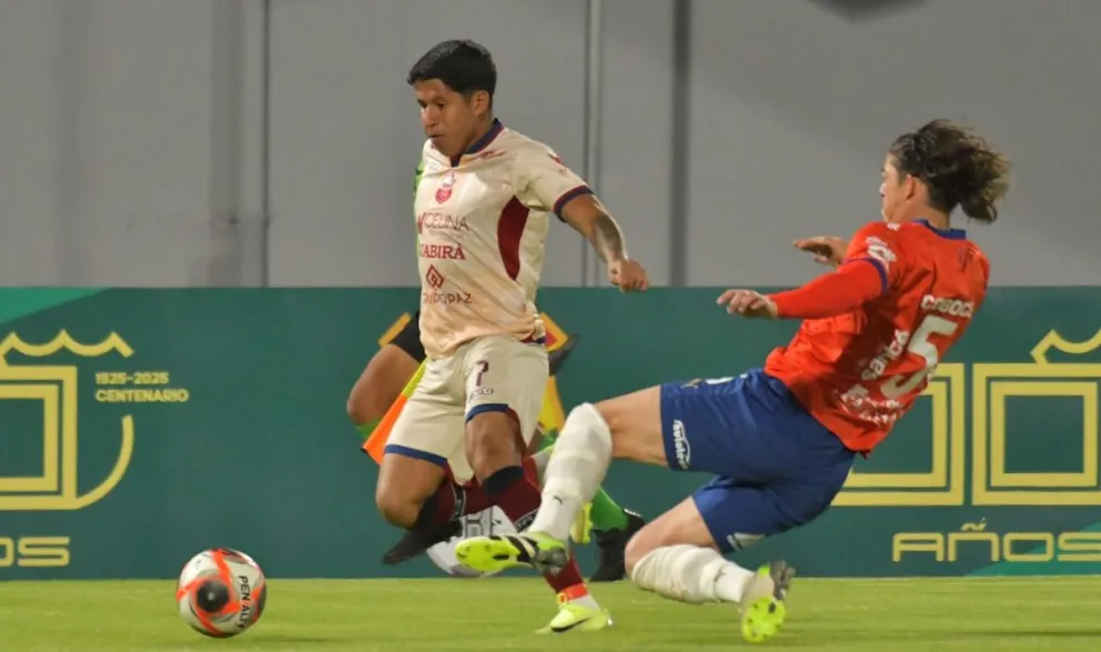 Gonzalo Castillo (der.), de Wilstermann, se lanza al piso en procura de frenar el avance de Gustavo peredo. Foto: Agencia Marka Registrada. 
