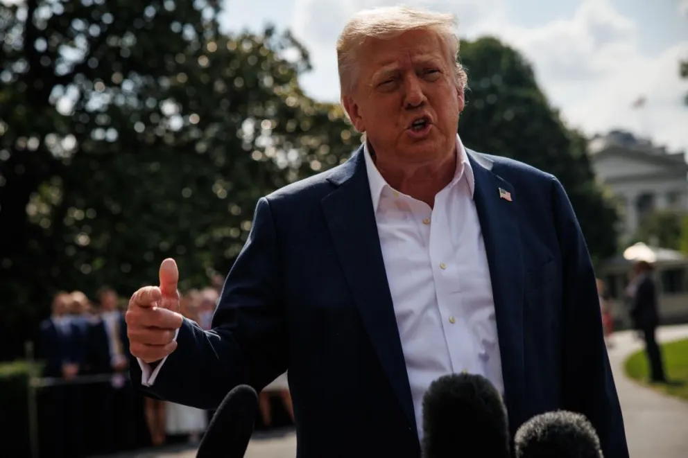 Trump responde a las preguntas de los reporteros después de salir del pórtico sur de la Casa Blanca. Foto: EFE