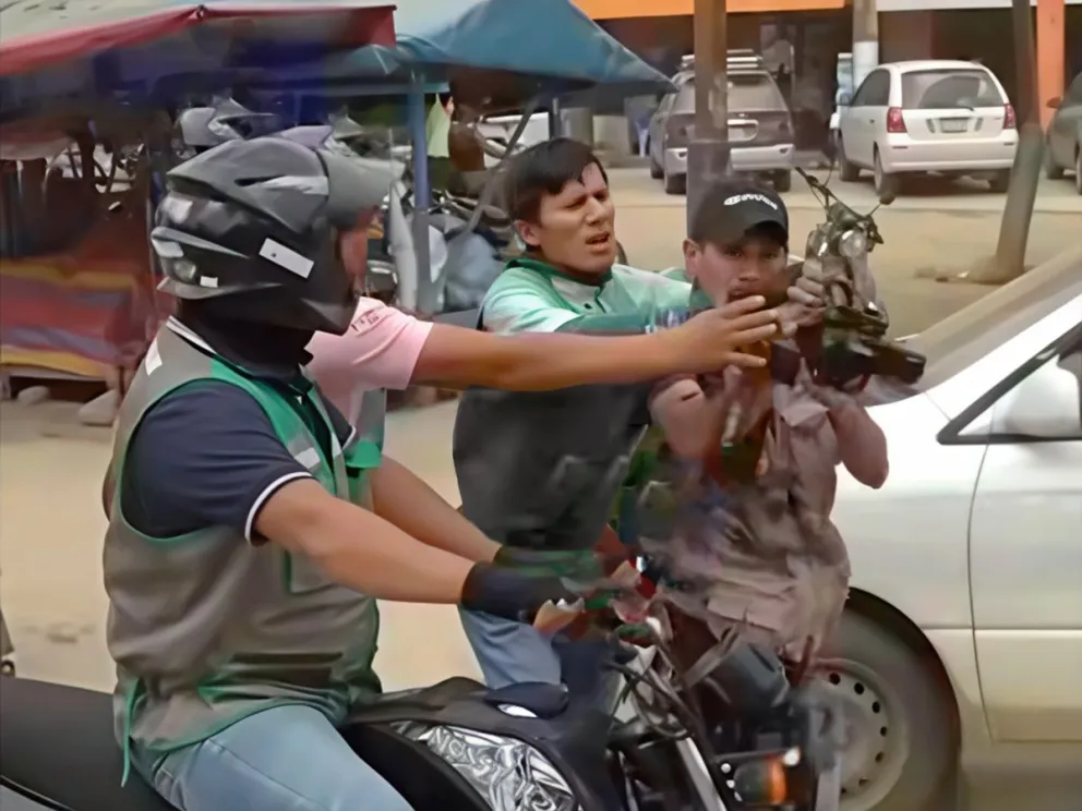 Un mototaxista y un ciudadano de Villa Yapacaní intentan arrebatar una cámara a un reportero de televisión. Foto: Captura de video