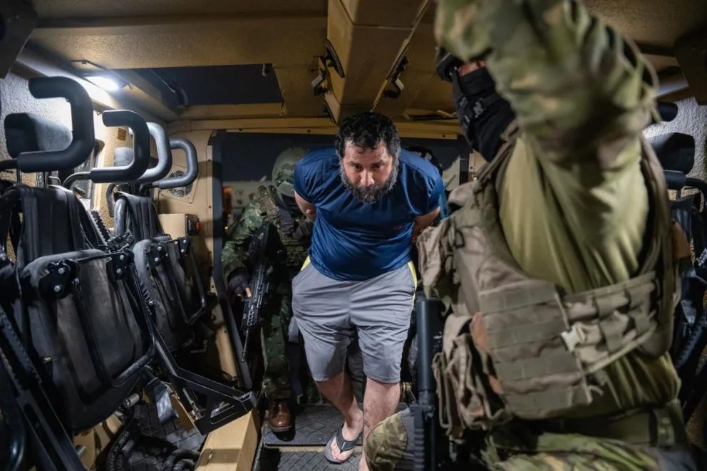 El narco José Adolfo Macías Villamar es custodiado a su llegada a la Base aérea de Guayaquil en junio. Foto: EFE