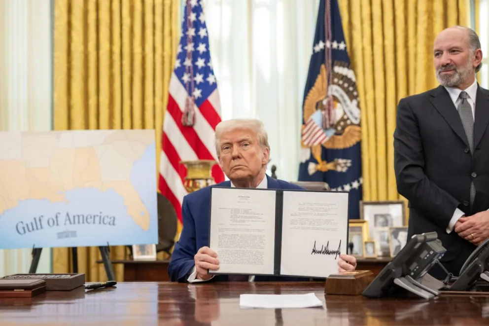 Fotografía cedida donde aparece el presidente de Estados Unidos, Donald Trump (c), mostrando la orden ejecutiva sobre el aumento de aranceles el 13 de febrero de 2025 en el Despacho Oval de la Casa Blanca en Washington (EEUU). Foto: EFE
