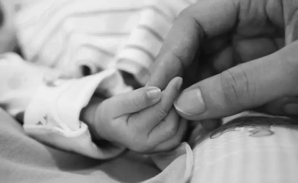 Una mamá agarra la mano de un bebé (imagen referencial). Foto: ABI