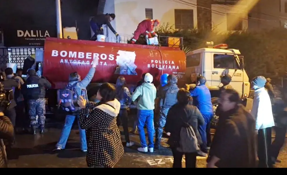 Vecinos y bomberos utilizan baldes para transportar agua y llenar el camión cisterna. Foto: Paulo Lizárraga / Visión 360
