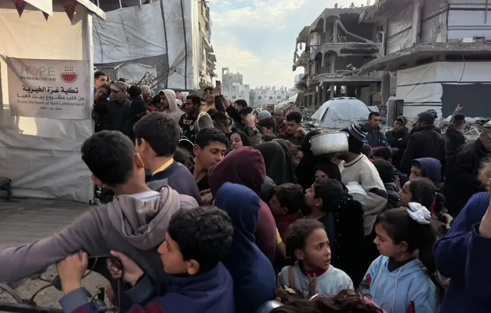 Decenas de niños acercan sus cacerolas en un reparto de comida en Beit Lahia, en el norte de Gaza. Foto: EFE