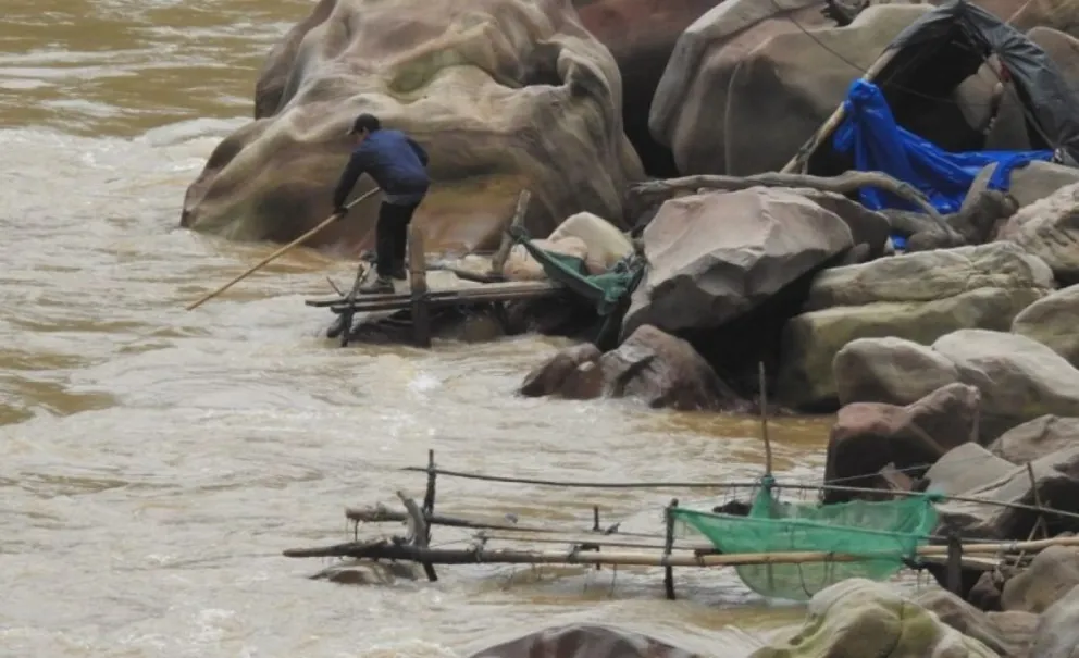 Pescador trabaja en un contaminado Pilcomayo. Foto: El País Tarija