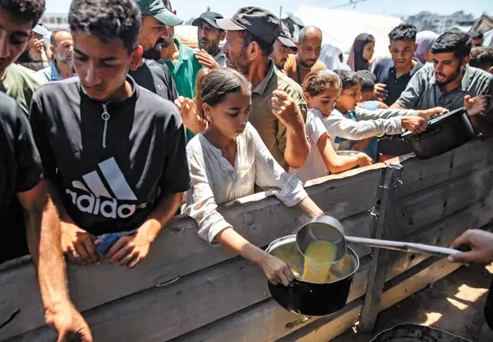 Niños palestinos desplazados en un punto de reparto de comida en la Franja de Gaza. Foto: EFE 