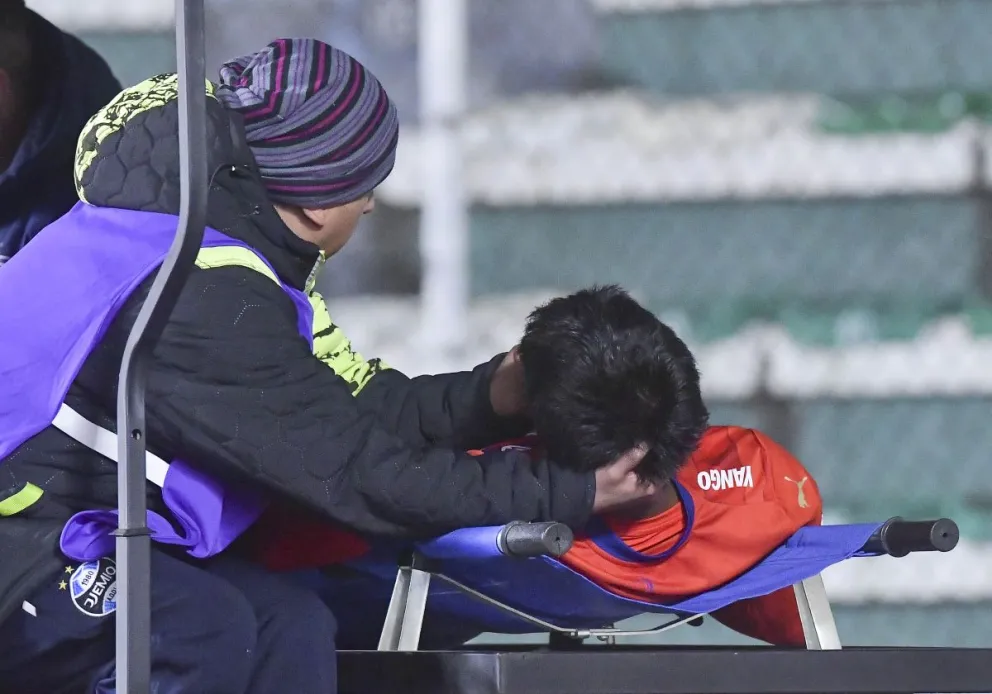 Uno de los médicos del club Wilstermann sostiene la cabeza de Adriel Guillermo antes de ser trasladado a la clínica. Foto: APG