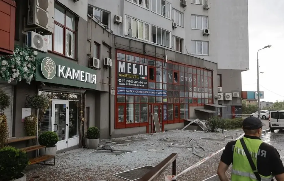 Residentes locales observan un edificio residencial alcanzado por un ataque con drones en Ucrania. Foto: EFE