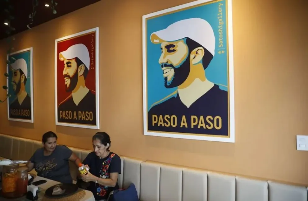 Personas en un restaurante con imágenes alusivas al presidente salvadoreño, Nayib Bukele, en el centro de San Salvador. Foto: EFE