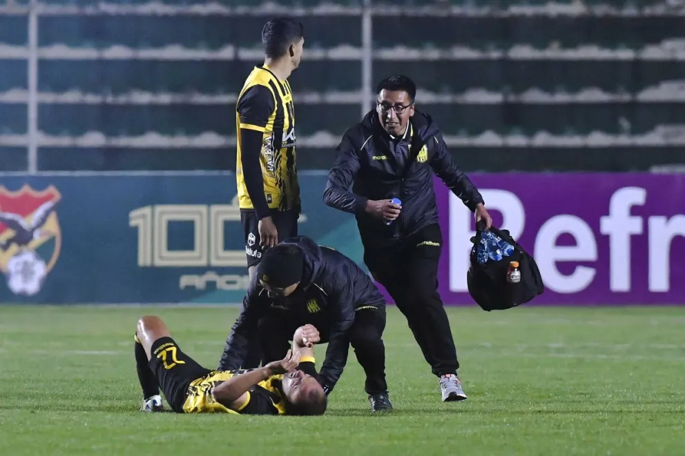 El jugador Juan Godoy es atendido por el personal médico de The Strongest tras ser impactado por un petardo. Foto: APG