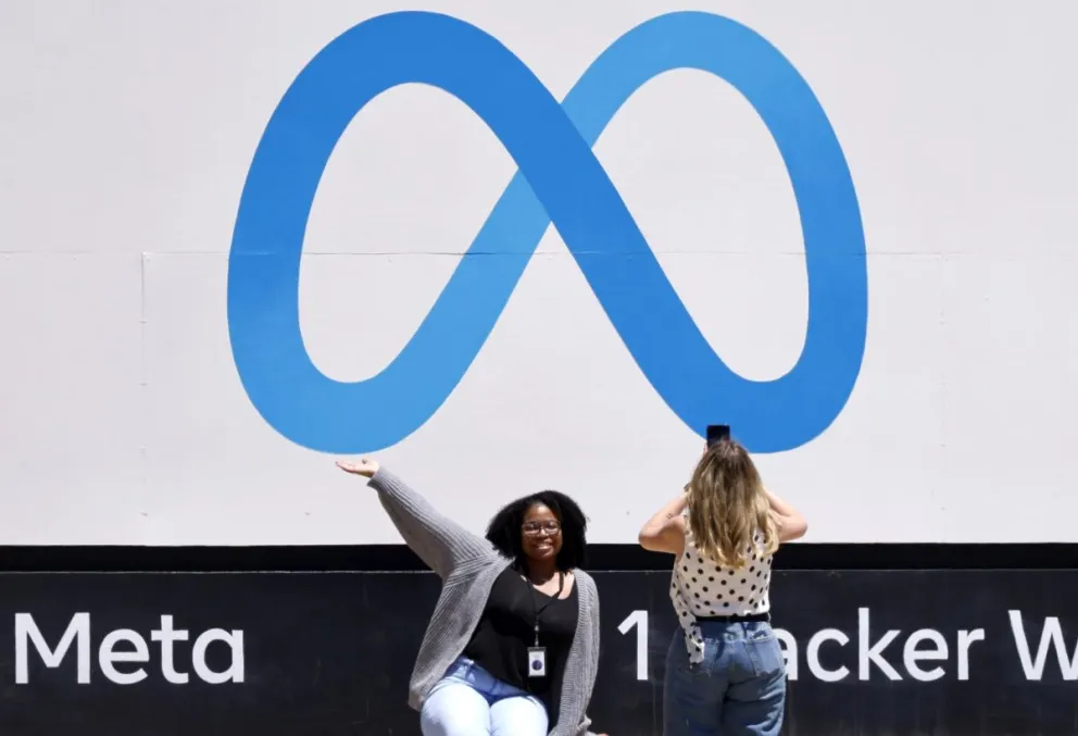 Una persona posa delante del letrero de Meta en la sede de Meta Platforms en Menlo Park (Estados Unidos). Fotos: EFE