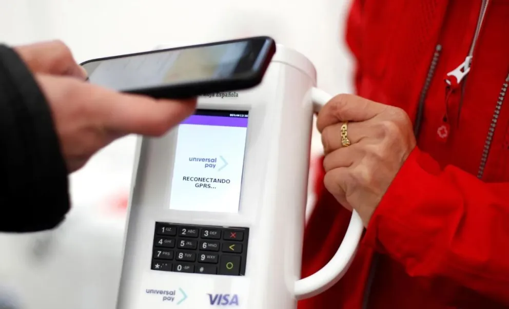 Un ciudadano hace una donación con su móvil a una voluntaria, en una imagen de archivo. Foto: EFE