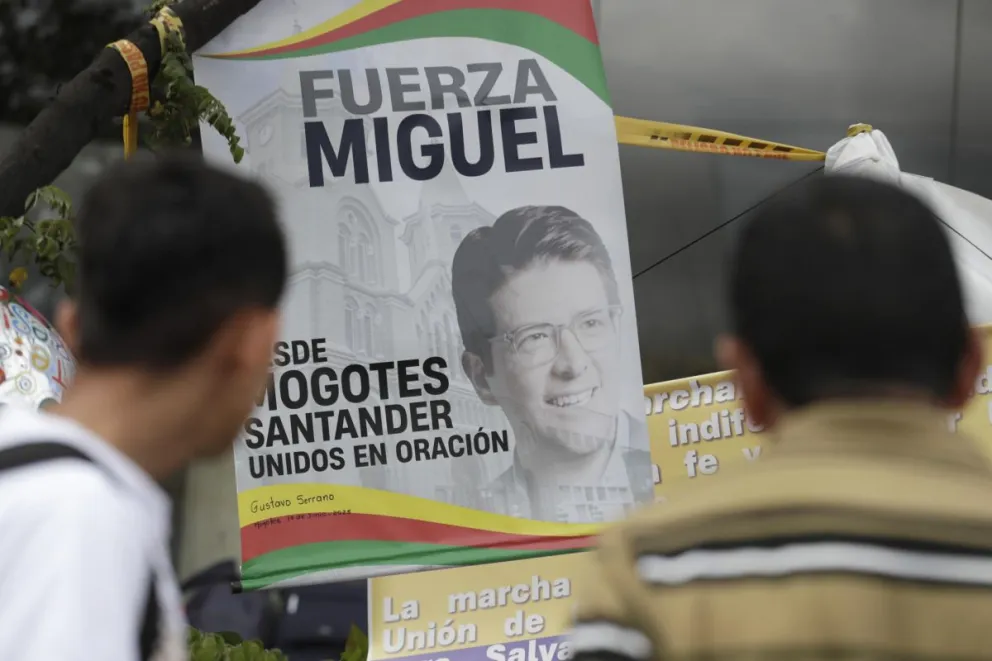 Personas orando en un altar improvisado frente a la Fundación Santa Fe, donde estaba hospitalizado el senador colombiano Miguel Uribe Turbay. Foto: EFE 