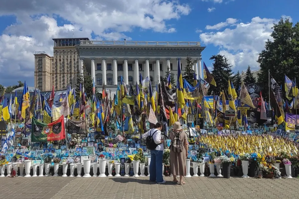 Dos personas frente a un monumento a los soldados ucranianos muertos en la guerra contra Rusia este lunes, en la Plaza de la Independencia en Kiev (Ucrania). Foto: EFE 