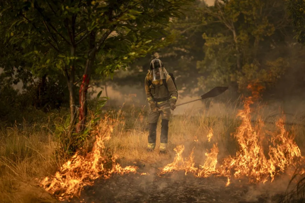 Un bombero forestal realiza labores de extinción en un nuevo incendio declarado este miércoles en A Gudiña (Orense, noroeste de España). Foto: EFE