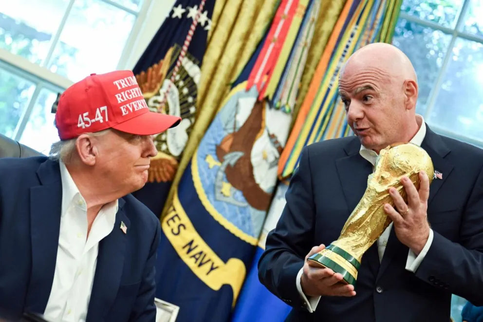 Infantino (der.) le muestra el trofeo del Mundial a Trump. Foto: EFE.