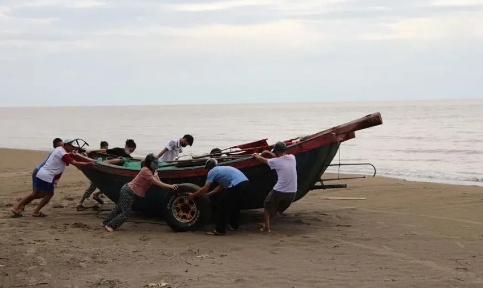 Personas en una playa de Vietnam, antes de la llegada del tifón Kajiki. Foto; EFE