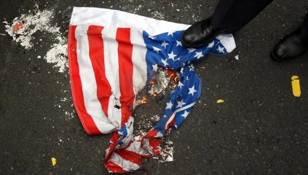 Fotografía de archivo de una bandera de Estados Unidos quemada. Foto: EFE