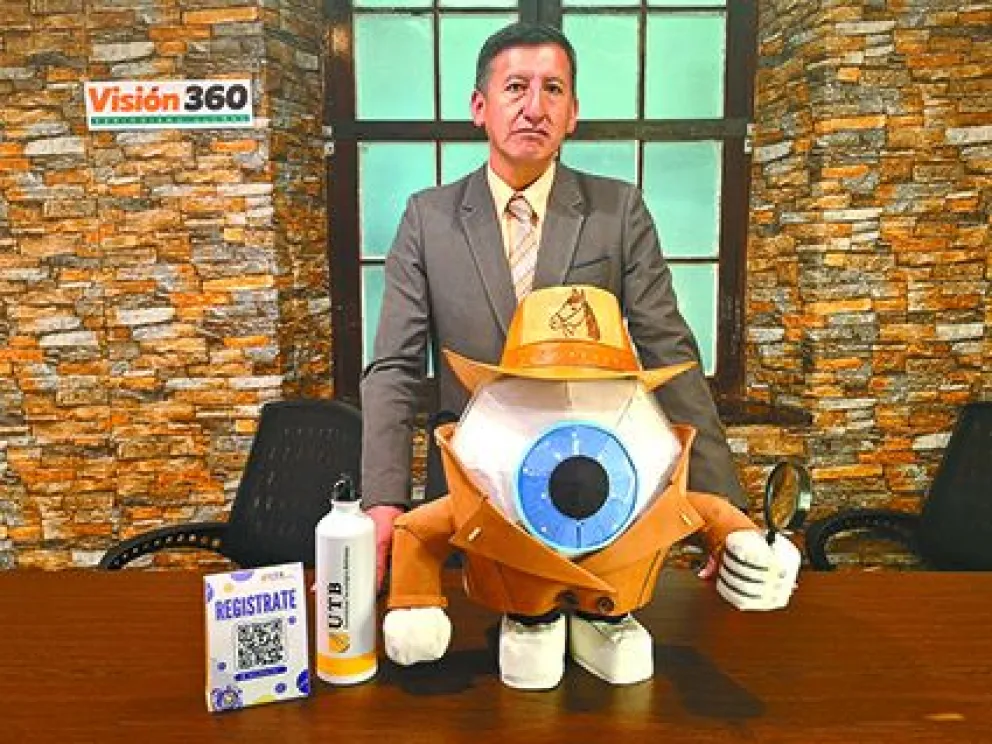 Rafael Díaz presenta a la mascota de Quidi, además de los códigos QR para poder inscribirse. FOTO: Marina Mamani / Visión 360