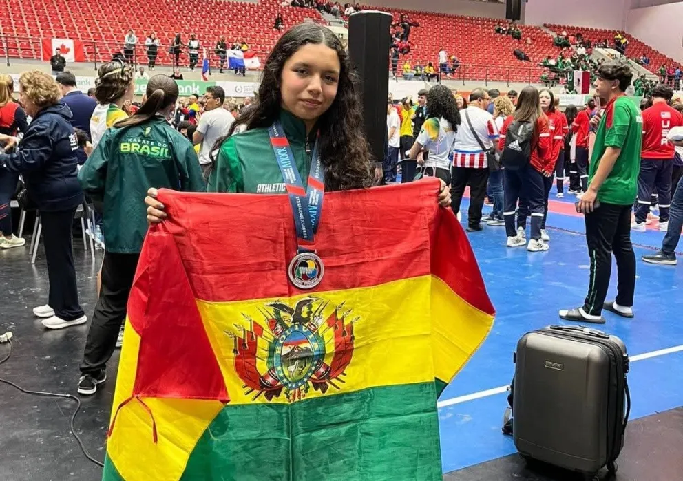 Patricia Saavedra con la medalla colgada al cuello y la bandera boliviana en sus manos. Foto: Feboka