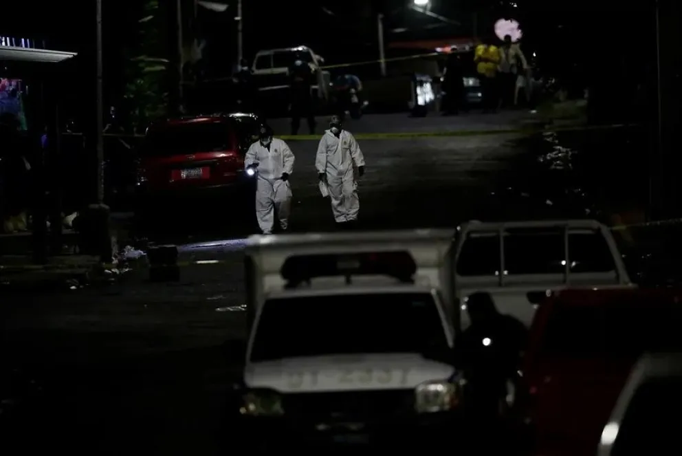 Investigadores de la Policía en la escena de un homicidio en San Salvador. Foto: EFE