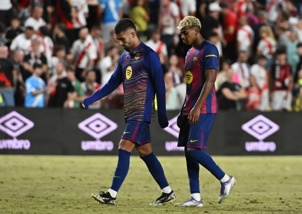 Lamine Yamal (der.) y Ferrán Torres, jugadores del Barcelona, se retiran cabizbajos después del empate ante el Rayo Vallecano. Foto: EFE