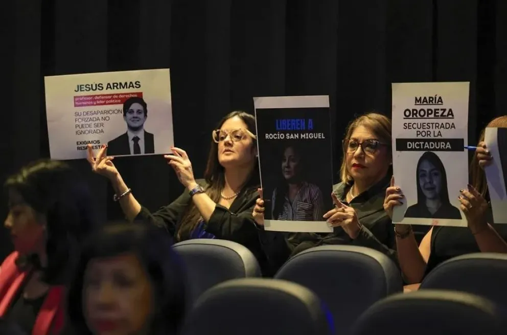 Personas sostienen carteles con la imagen de ciudadanos detenidos, este martes durante el conversatorio "Venezuela Memoria y Justicia", en ciudad de Panamá. Foto: EFE