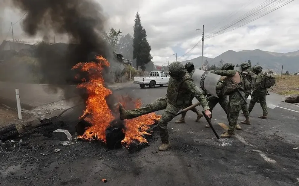 Integrantes de las Fuerzas Armadas remueven escombros después de una protesta en la avenida panamericana norte este martes, en Tabacundo (Ecuador). Fotos: EFE
