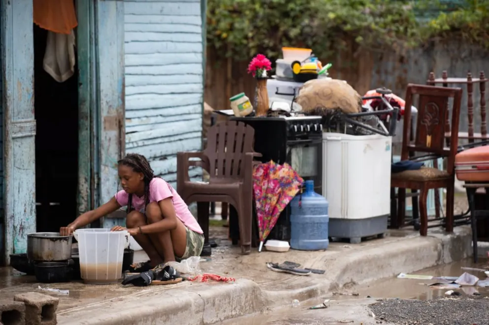 Una mujer recoge sus pertenencias luego de una inundación este viernes, en Azua (República Dominicana). FOTO: EFE/ Orlando Barría