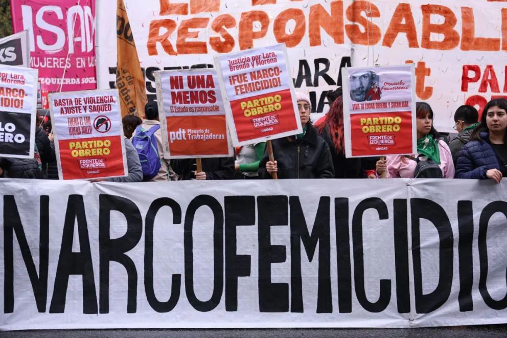 Personas sostienen carteles durante una manifestación este sábado, por el triple feminicidio. Foto EFE