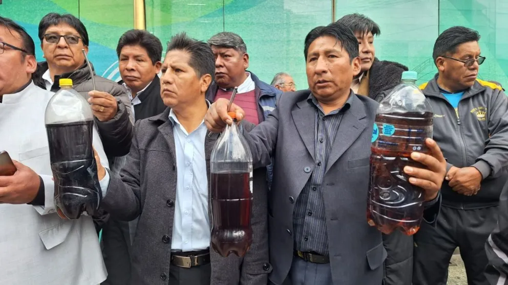 Choferes muestran en botellas la calidad del combustible que se está cargando a sus movilidades, en una protesta en puertas de la ANH. Fotos: M. Belmonte