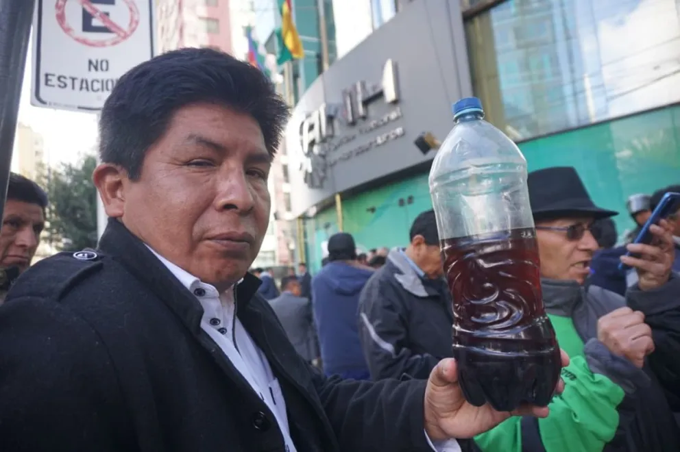 Un transportista muestra combustible, este lunes, que, aseguran los choferes, está causando daños en los vehículos. Foto: APG