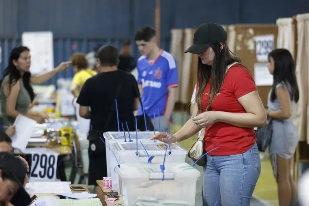 Fotografía de archivo de varias personas ejerciendo su voto en un puesto de votación, en Santiago (Chile). Foto: EFE