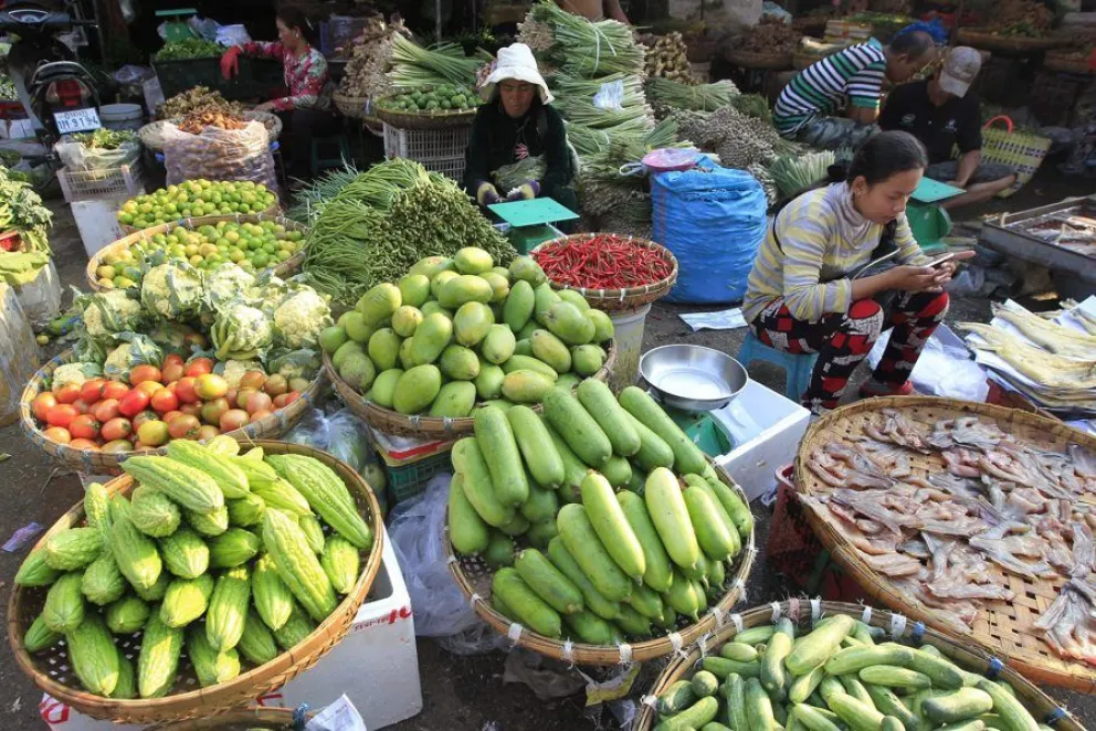En la imagen de archivo, un grupo de comerciantes camboyanos vende verduras en sus puestos del mercado de Nom Pen (Camboya). EFE/Kith Serey