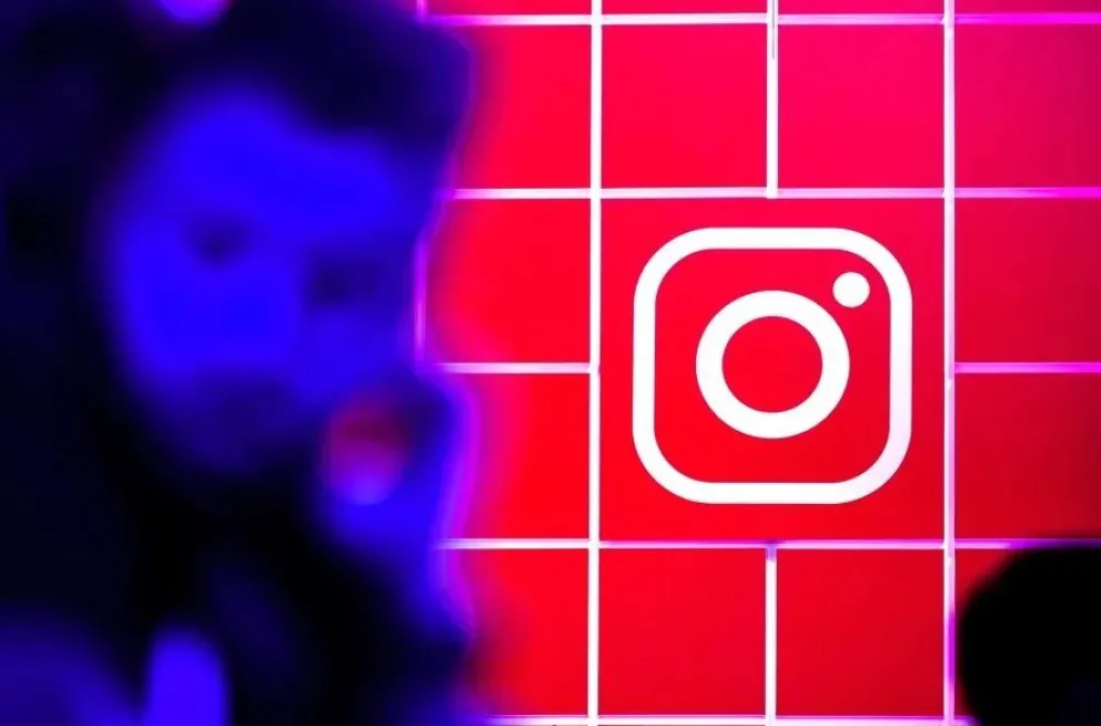 Una persona junto al logo de Instagram en una imagen de archivo. Foto: EFE