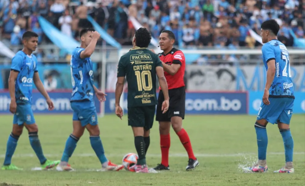 El árbitro Alemán (de rojo) habla con los futbolistas de ambos planteles. Foto: Agencia Marka Registrada.