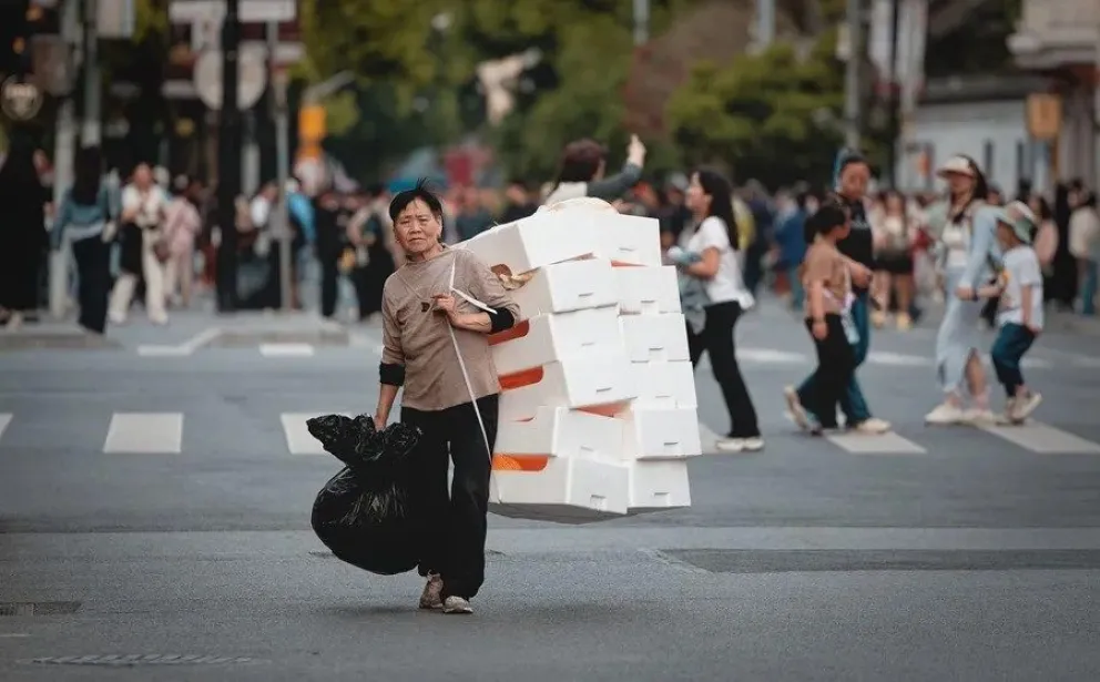Una mujer carga cajas en la calle en Shanghái, China, en una fotografía de archivo. EFE/EPA